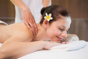 Woman smiling while receiving shoulder massage