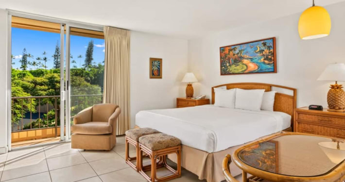 hotel room with bed, seating area for dining and sliding doors to the outdoor lanai
