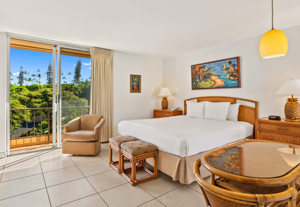 hotel room with bed, seating area for dining and sliding doors to the outdoor lanai