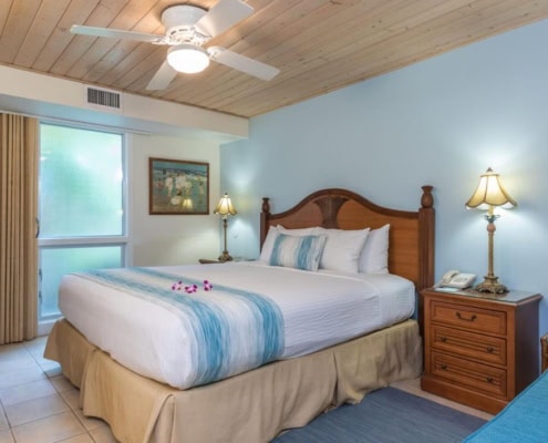 condo bedroom with bed night stands, lamps and seating area