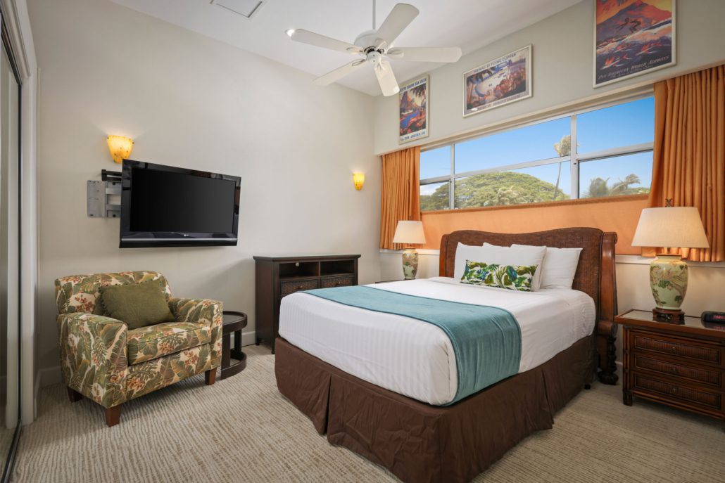bedroom with a wall mounted television and a separate seating