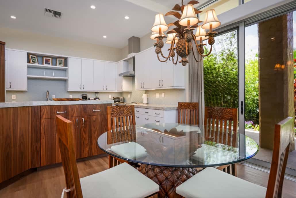 dining room area with seating for five and a full kitchen in the background