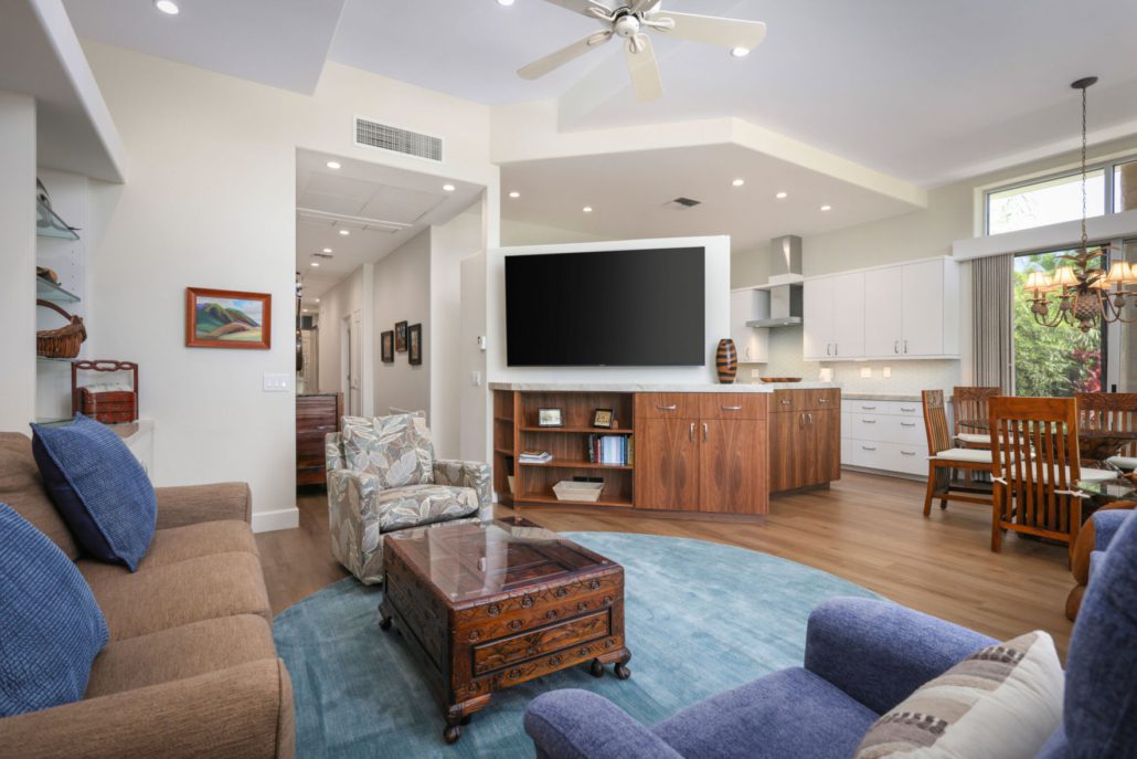 living room area with all the furnishings of a full set including a coffee table with a wall mounted television and a separate dining area