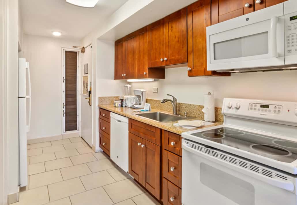 full kitchen with full size refrigerator, stove and microwave and countertop appliances
