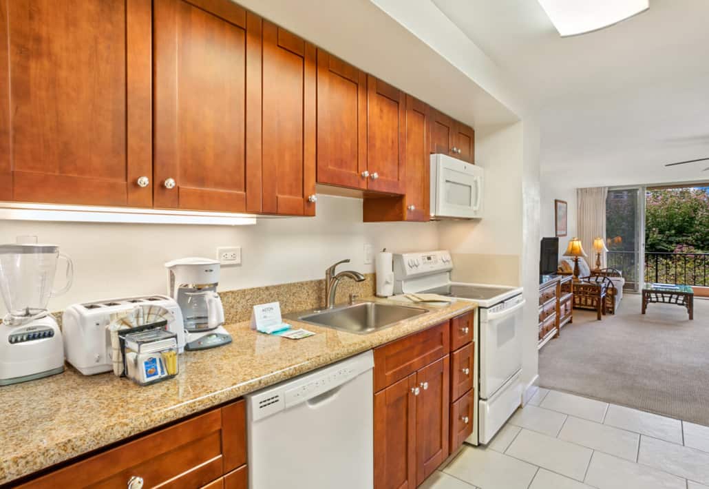 kitchen with disherwasher, stove, microwave lookig out to the living room with views of the outdoor