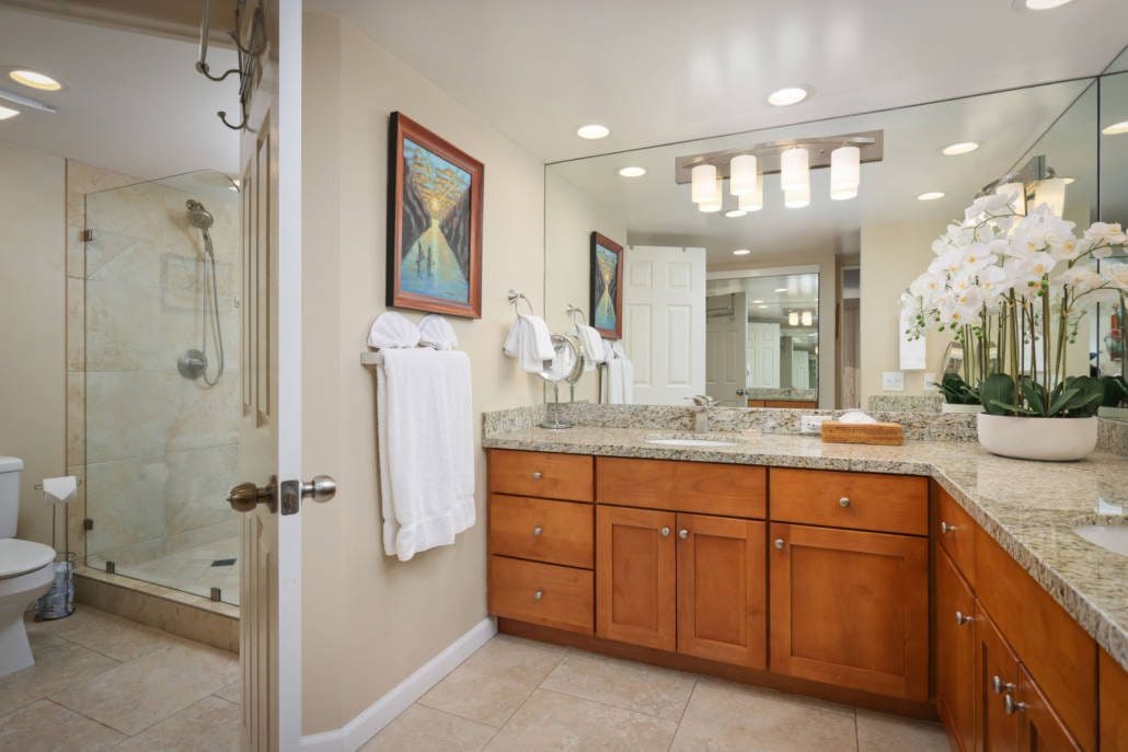 bathroom with a separate area for a shower, two person sinks and spacious counters