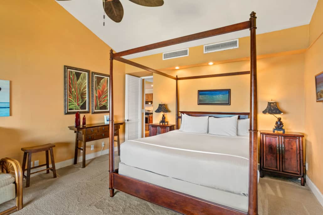 Bedroom with bed, side tables, lamps and a separating seating space
