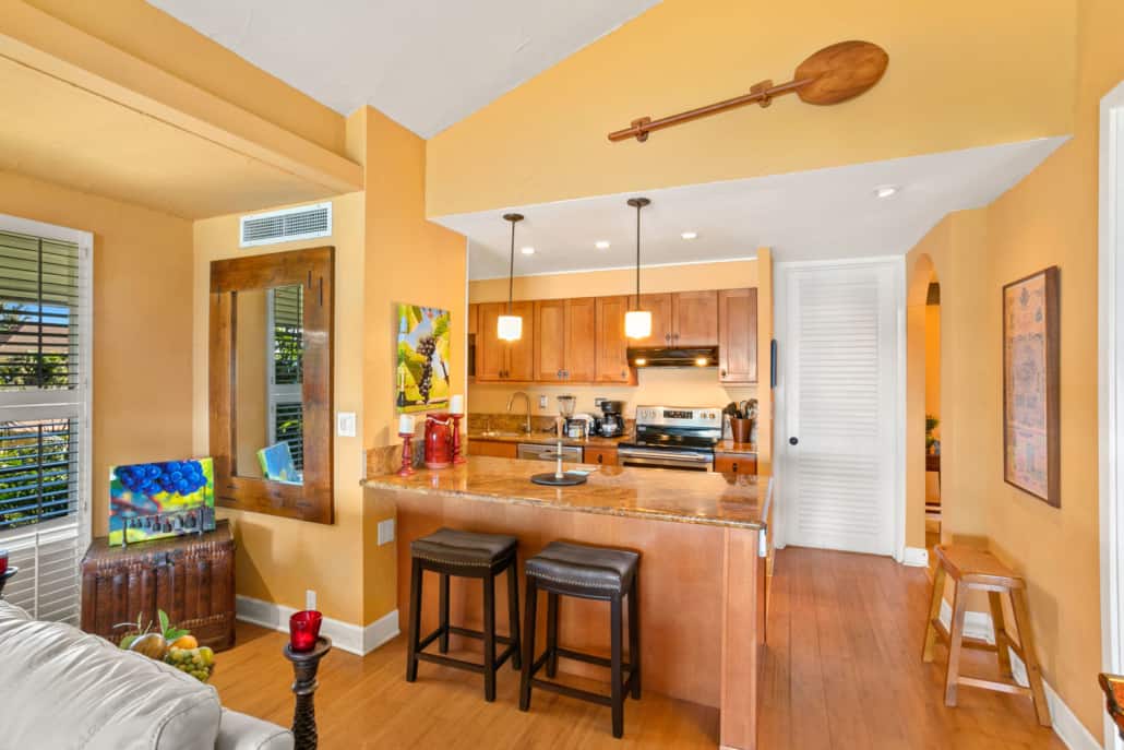 Kitchen with bar stool seating, stove and oven dish wather and a coffee maker