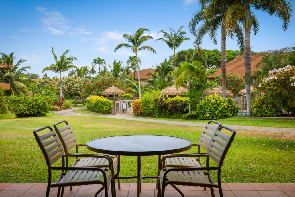covered lanai with outdoor seating for dining options and views of the garden and gated pool area