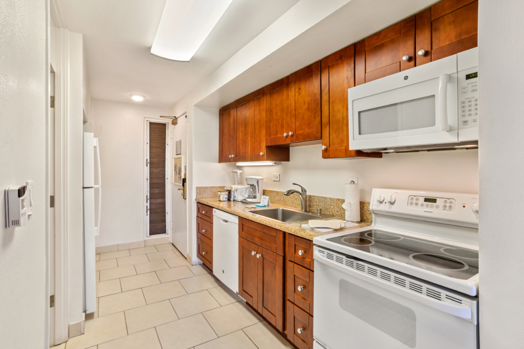 spacious kitchen with dishwasher, full stove, microwave, refrigerator, and counter top appliances